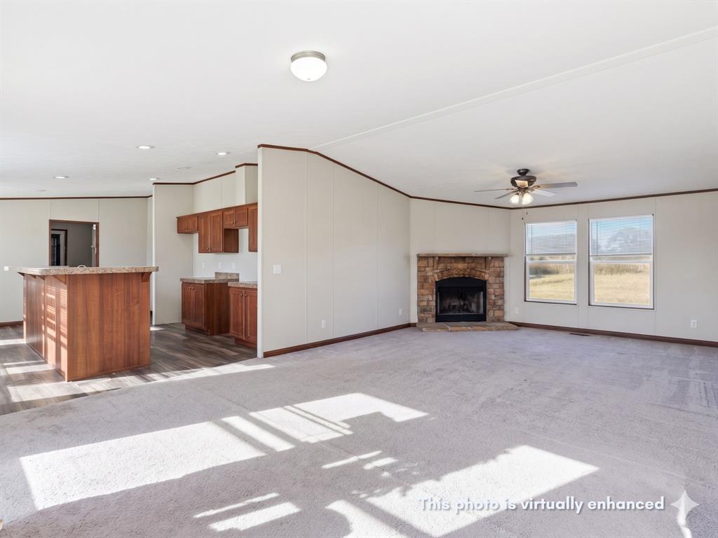 2722 Denver Road Sunset, TX 76270 - Photo 3 of 19 Spacious living area featuring light-colored carpeting, a stone-surround fireplace, and multiple windows