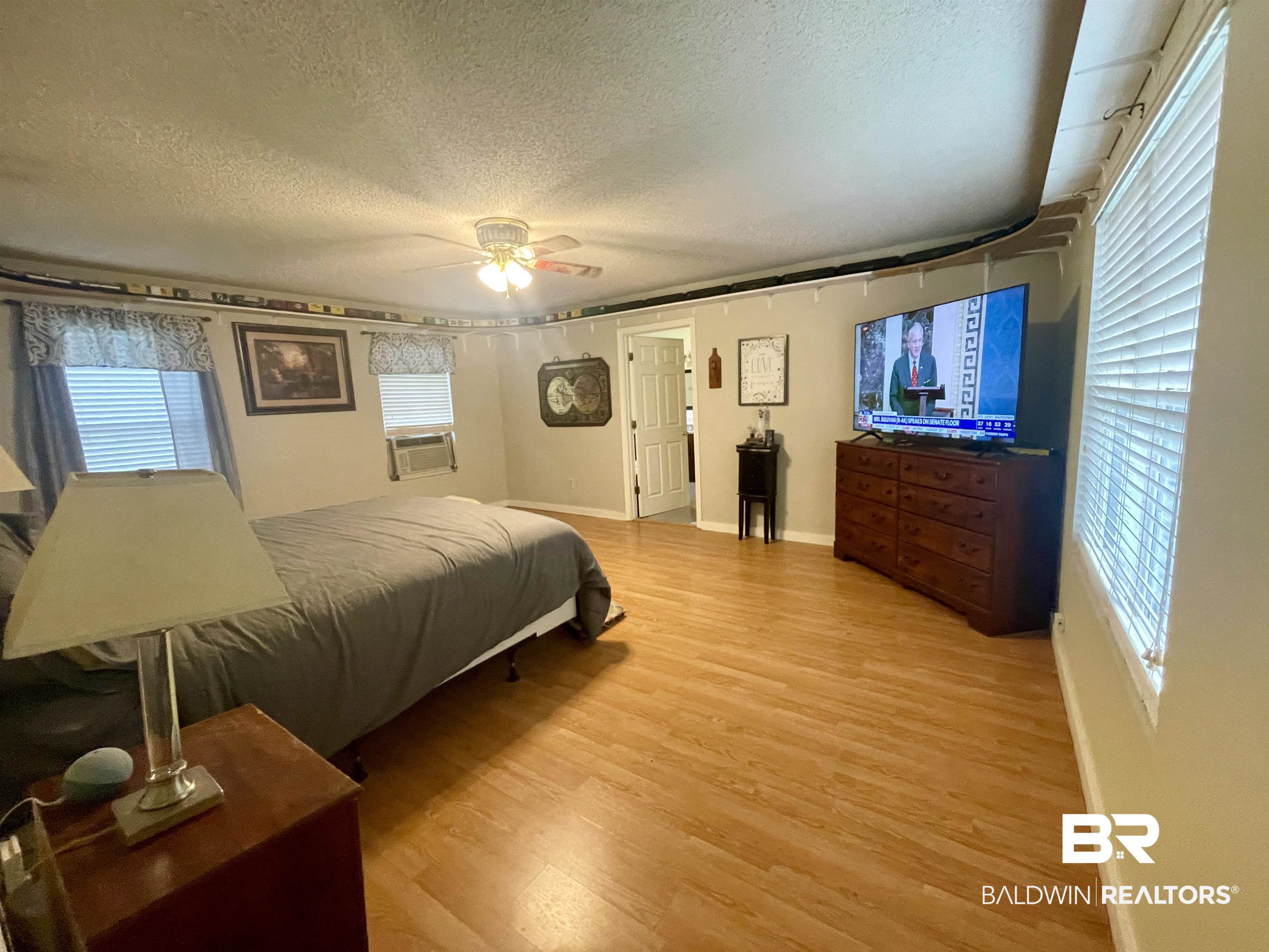 13850 Celeste Road Chunchula, AL 36521 - Photo 13 of 29 Bedroom with light wood finished floors, a textured ceiling, ceiling fan, and cooling unit
