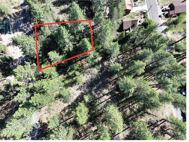 an aerial view of residential house with sign board and trees