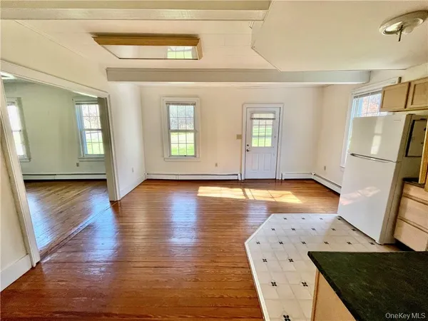 a view of a kitchen with wooden floor and a window