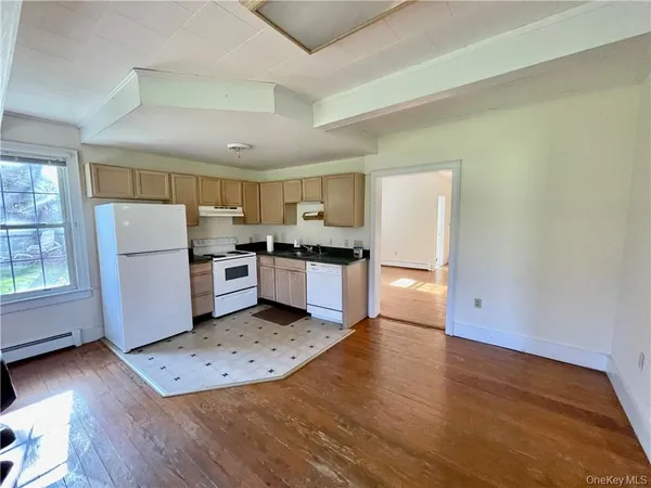 a kitchen with a refrigerator a stove top oven a sink and a counter space