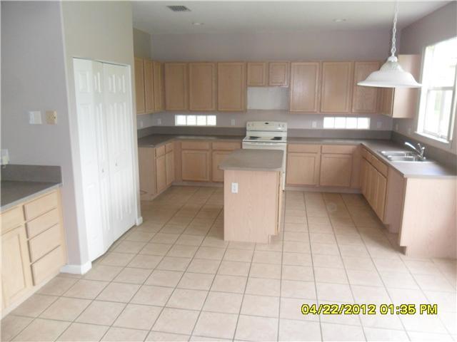 1093 Center Stone Lane Riviera Beach, FL 33404 - Photo 2 of 4 a kitchen with cabinets and white stainless steel appliances