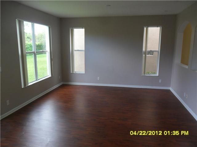 1093 Center Stone Lane Riviera Beach, FL 33404 - Photo 4 of 4 an empty room with wooden floor and windows
