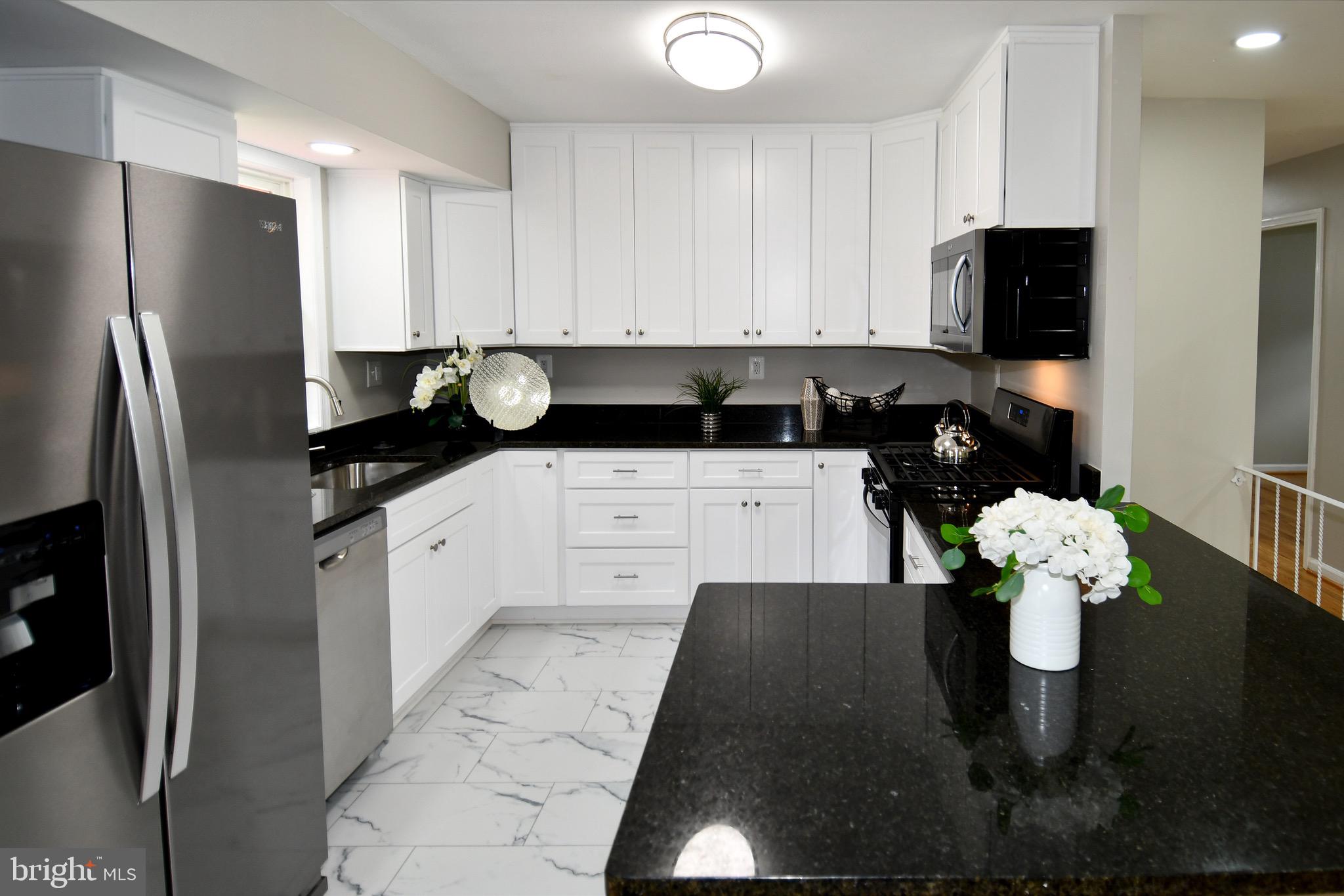 9616 Small Drive Clinton, MD 20735 - Photo 13 of 50 a kitchen with stainless steel appliances granite countertop a refrigerator a stove a microwave a sink and white cabinets