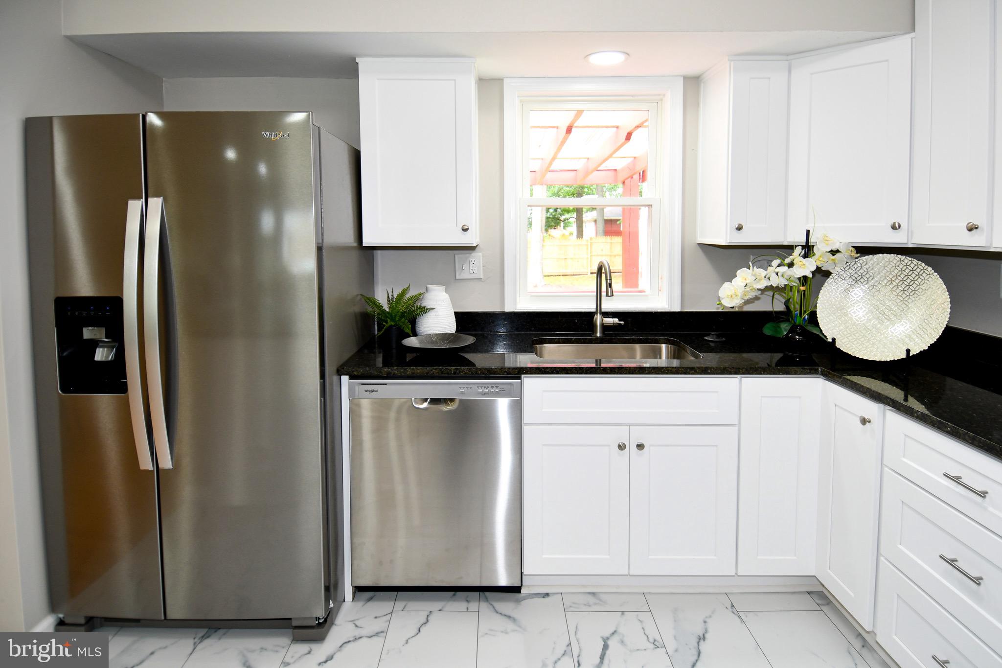 9616 Small Drive Clinton, MD 20735 - Photo 15 of 50 a kitchen with stainless steel appliances granite countertop a refrigerator a sink and white cabinets