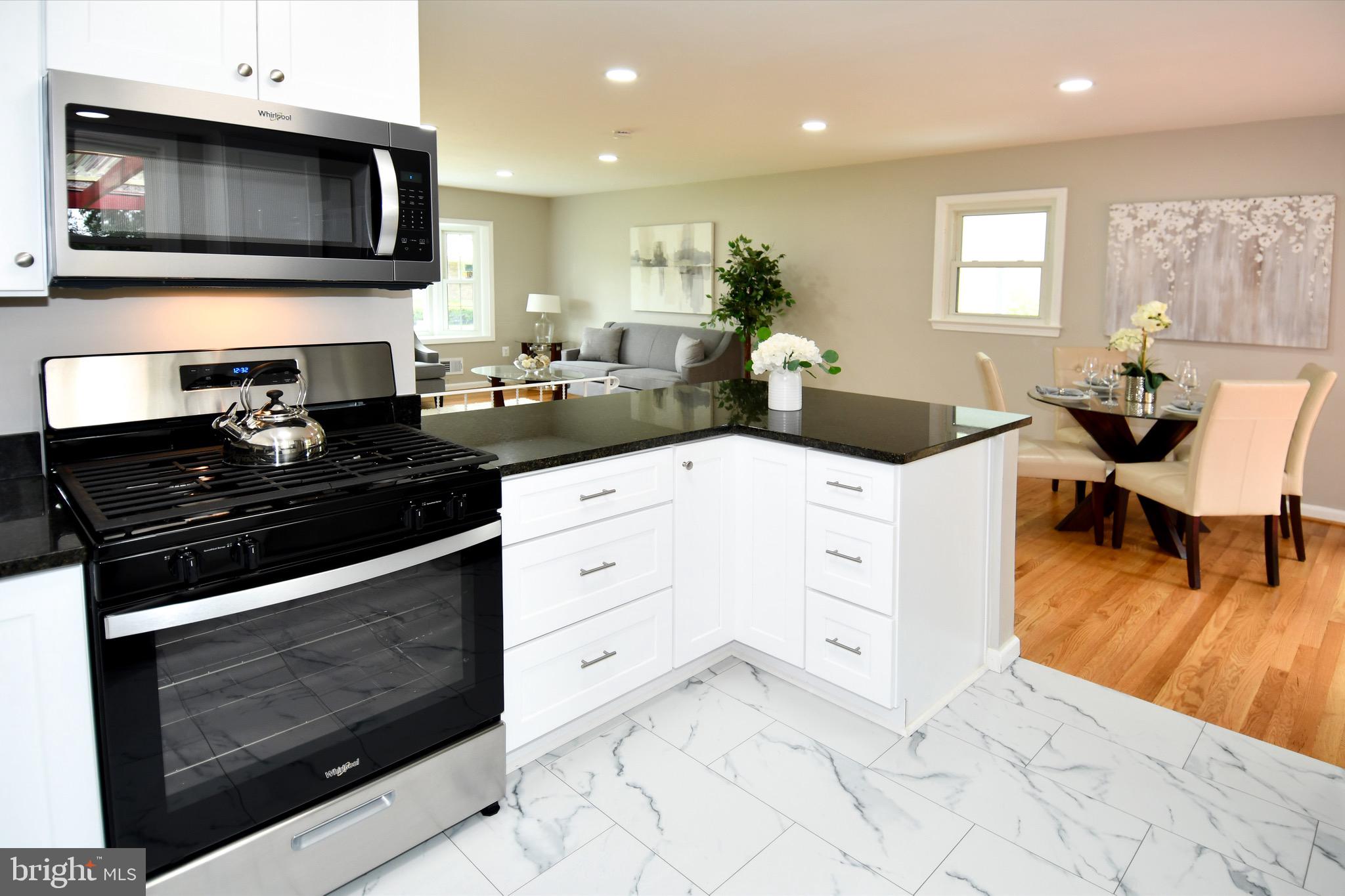 9616 Small Drive Clinton, MD 20735 - Photo 16 of 50 a kitchen with stainless steel appliances kitchen island granite countertop a stove a sink and a microwave