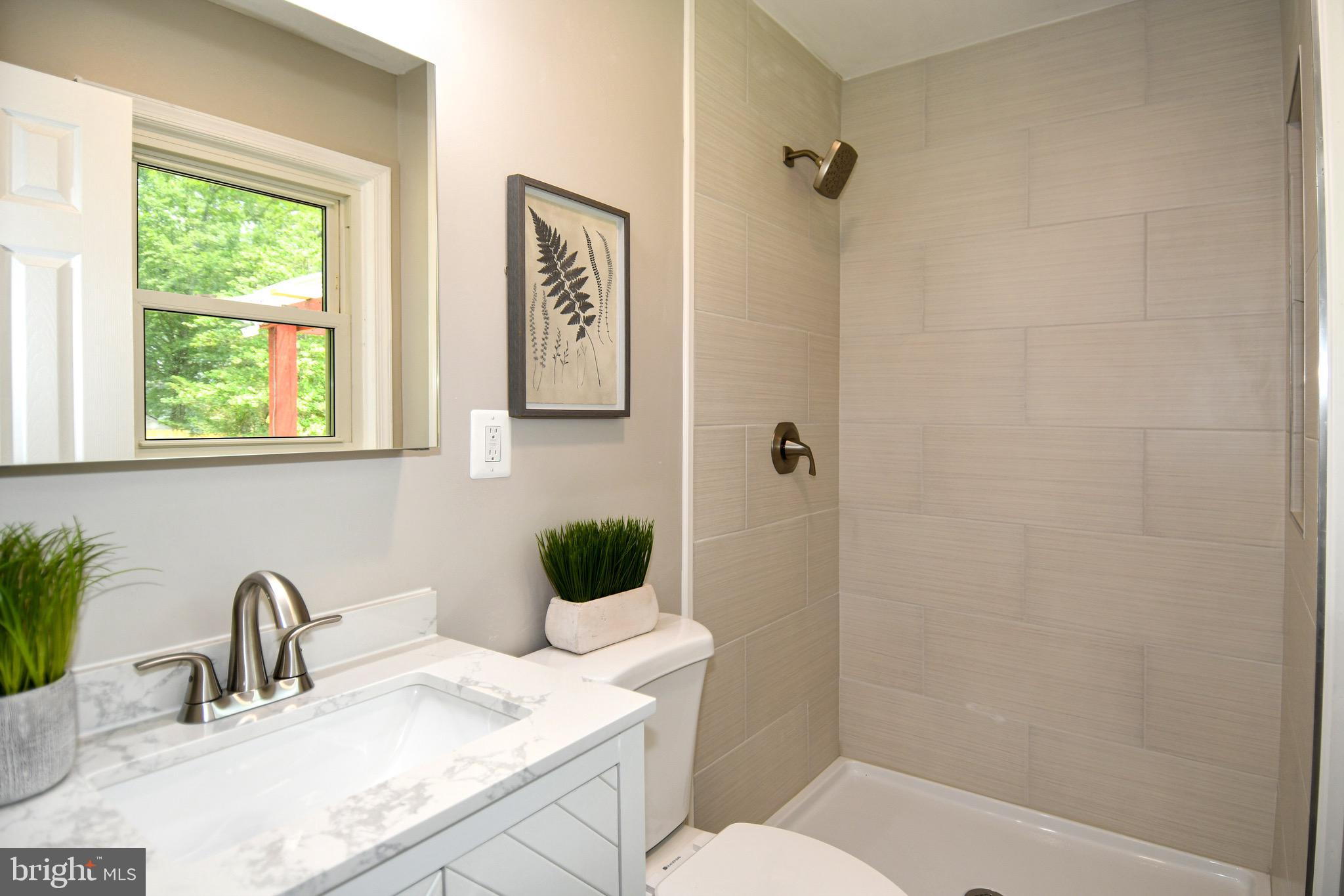 9616 Small Drive Clinton, MD 20735 - Photo 35 of 50 a bathroom with a granite countertop sink toilet and shower