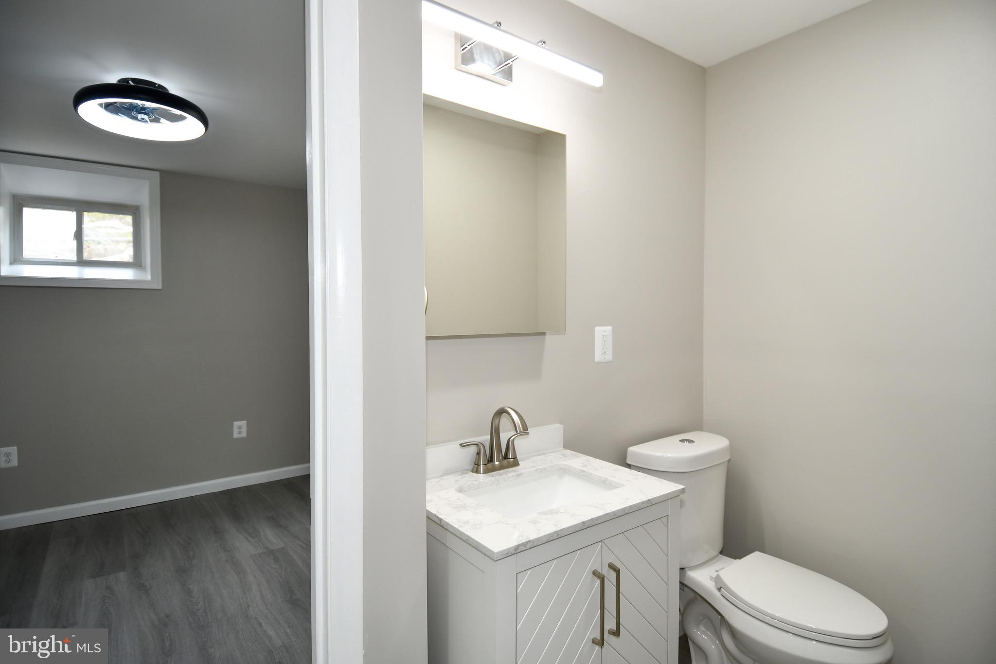 9616 Small Drive Clinton, MD 20735 - Photo 43 of 50 a bathroom with a toilet a sink a mirror and vanity