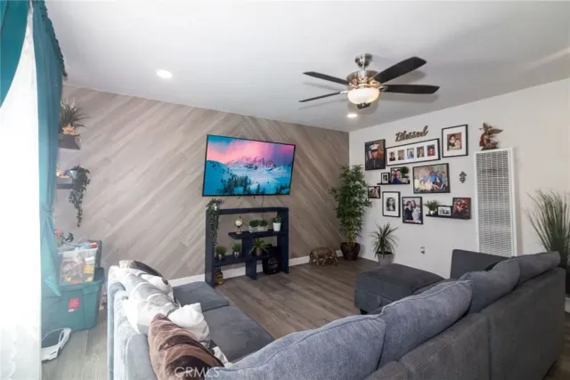a living room with furniture and a flat screen tv with kitchen view