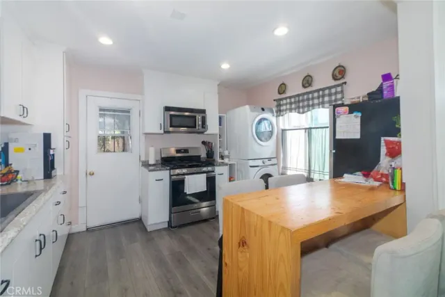 a kitchen with granite countertop a sink appliances cabinets and counter space