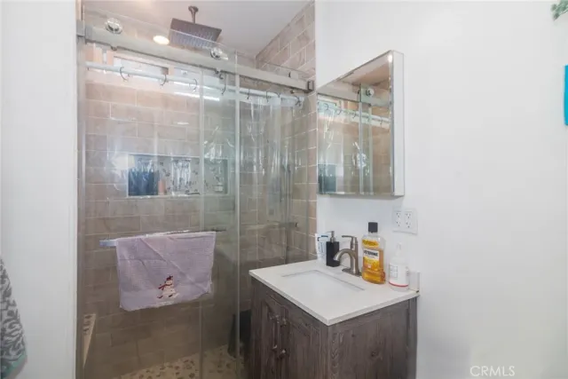 a bathroom with a shower sink and mirror