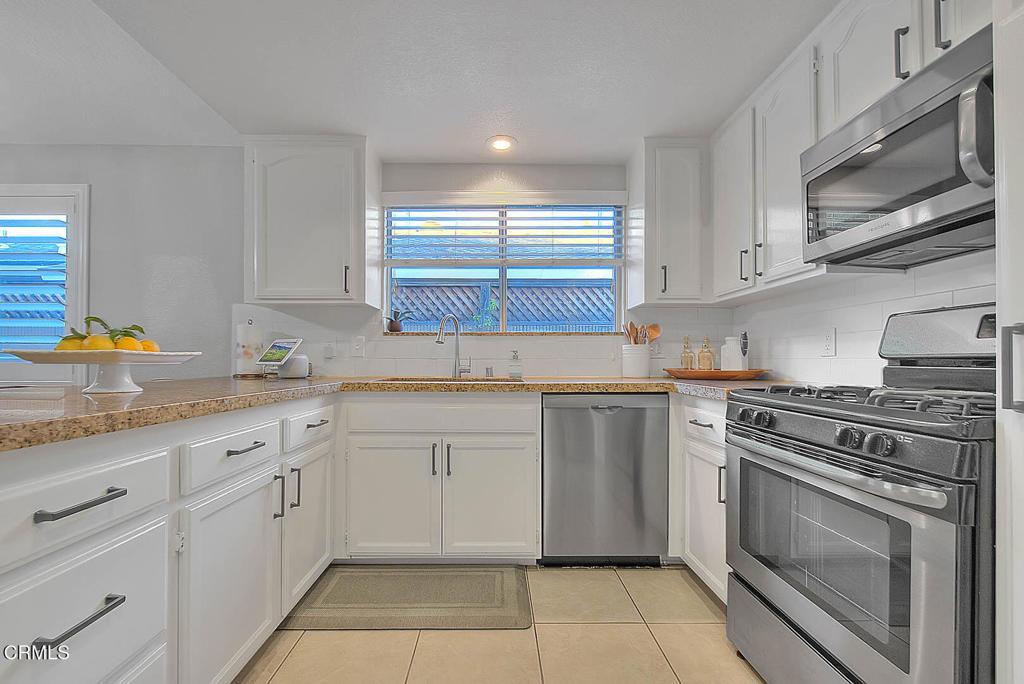 420 West 3rd Street San Dimas, CA 91773 - Photo 10 of 19 a kitchen with granite countertop white cabinets stainless steel appliances and sink