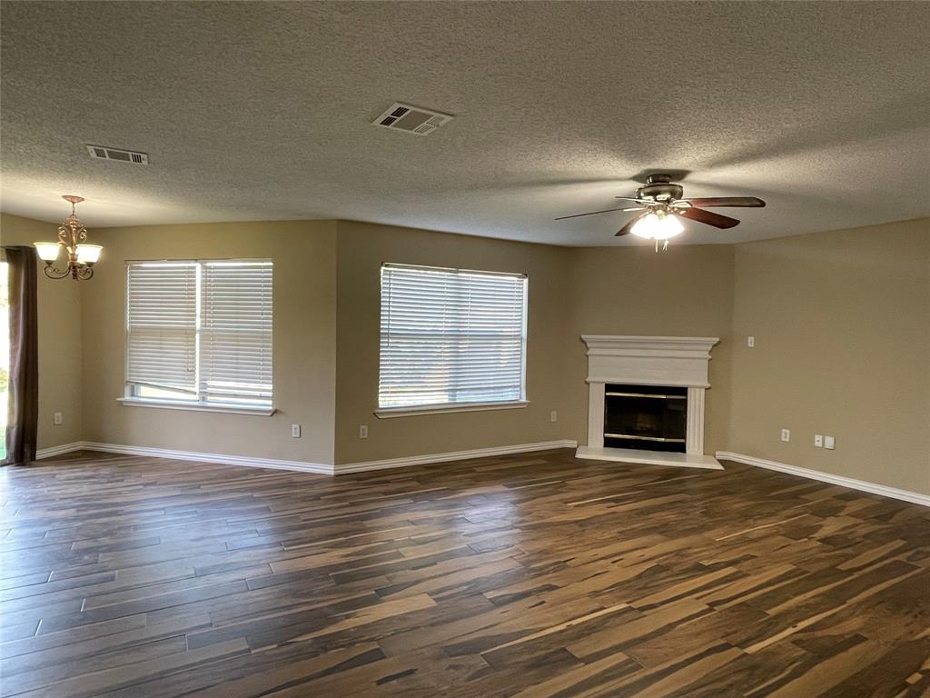 4855 Diamond Trace Trail Fort Worth, TX 76244 - Photo 3 of 21 a view of an empty room with wooden floor fireplace and a window