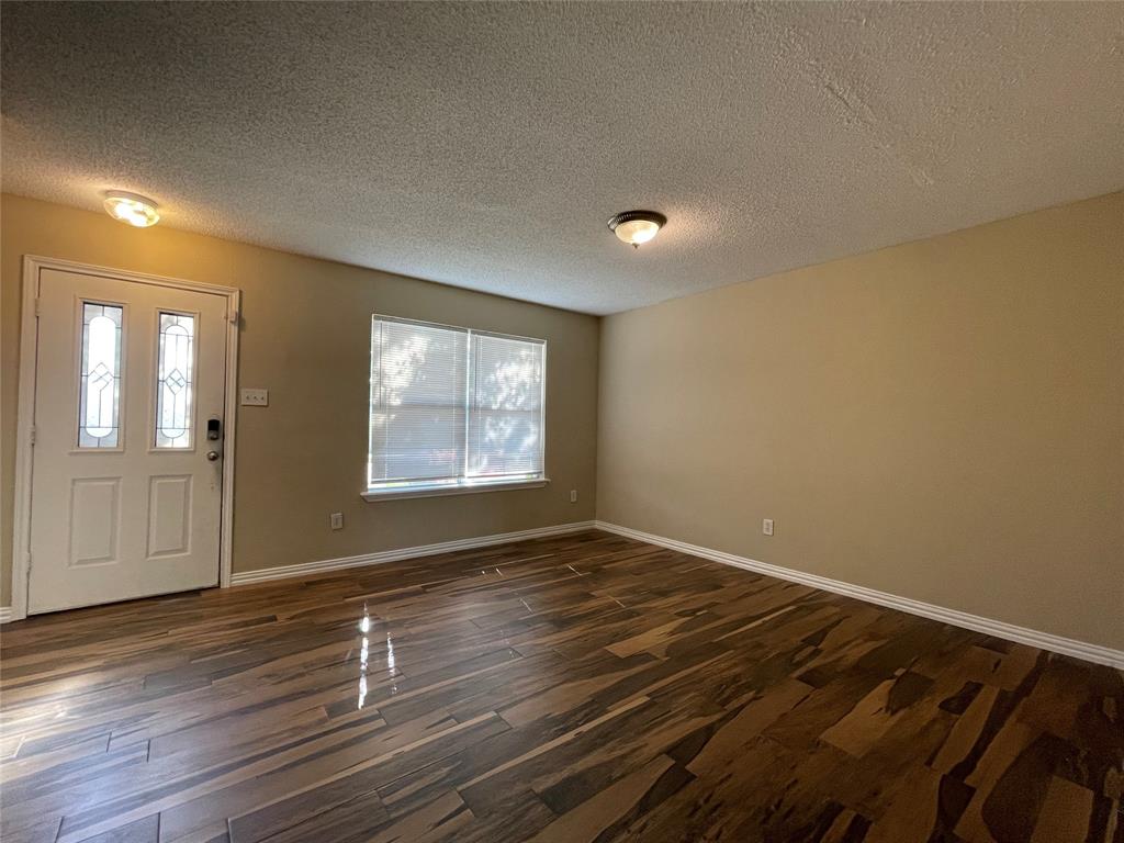 4855 Diamond Trace Trail Fort Worth, TX 76244 - Photo 9 of 21 a view of an empty room with wooden floor and a window