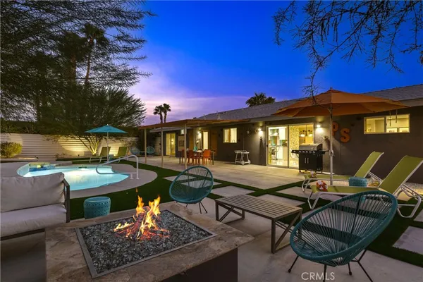 a view of a house with backyard water fountain and sitting area