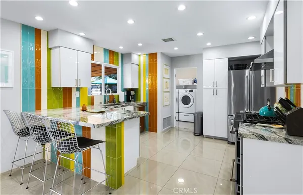 a kitchen with stainless steel appliances kitchen island granite countertop a stove a sink and a refrigerator