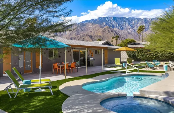 a view of a house with backyard sitting area and swimming pool