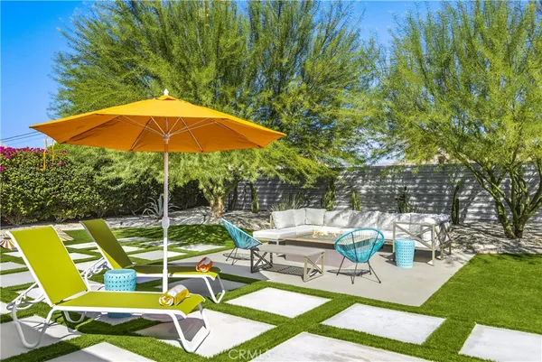 a view of a patio with a dining table and chairs under an umbrella