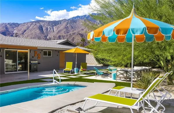 a roof deck with table and chairs under an umbrella
