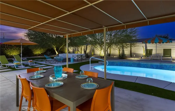 a view of a house with swimming pool and sitting area