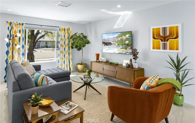 a living room with patio furniture and a potted plant