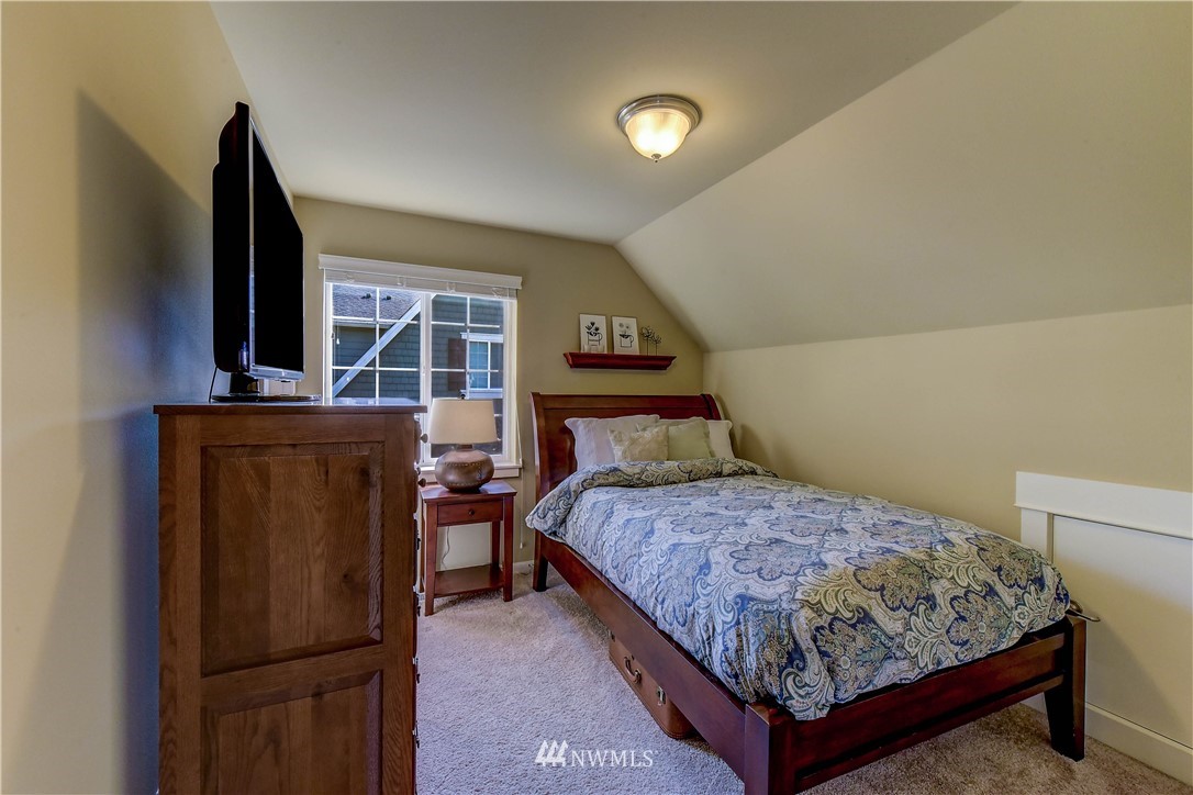 21802 38th Drive Southeast Bothell, WA 98021 - Photo 17 of 26 a bedroom with a bed and a flat tv screen on dresser