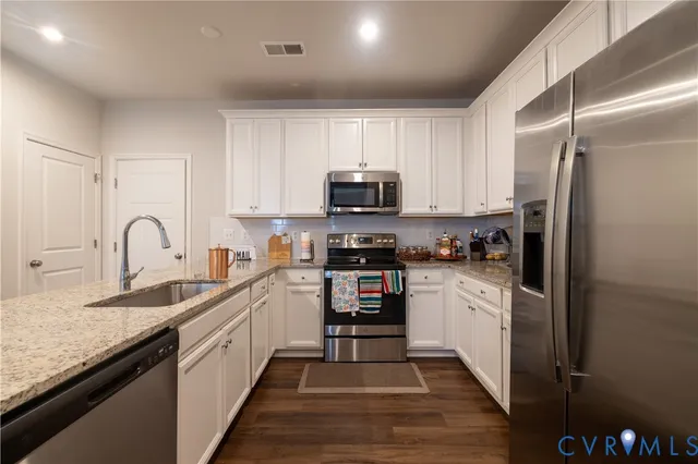 a kitchen with sink a microwave and cabinets