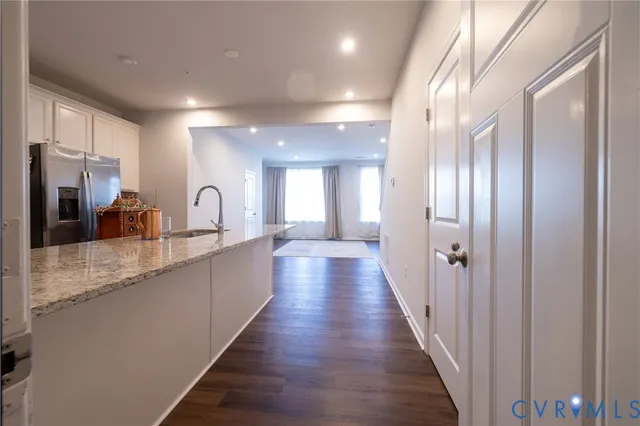 a large kitchen with stainless steel appliances a large counter top a sink and a refrigerator