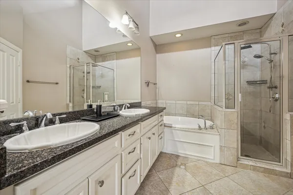 a bathroom with a granite countertop sink a mirror a shower and a bathtub