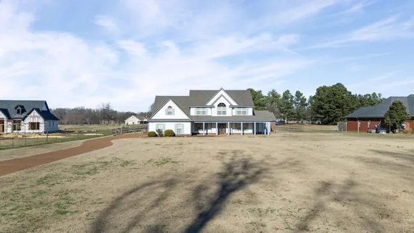 an aerial view of a house with a big yard and large trees