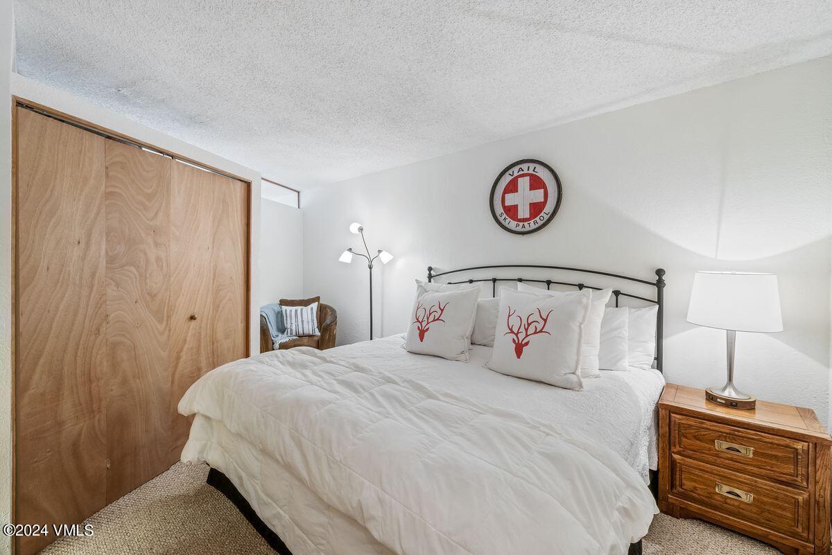 442 South Frontage Road East, Unit A205 Vail, CO 81657 - Photo 11 of 24 a bedroom with a bed and a lamp