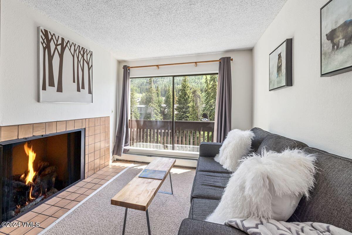 442 South Frontage Road East, Unit A205 Vail, CO 81657 - Photo 5 of 24 a living room with furniture a fireplace and a flat screen tv