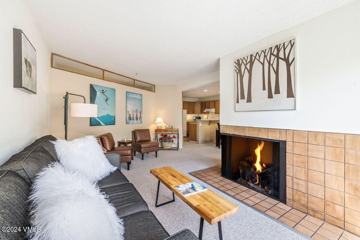 442 South Frontage Road East, Unit A205 Vail, CO 81657 - Photo 6 of 24 a living room with furniture a fireplace and a table