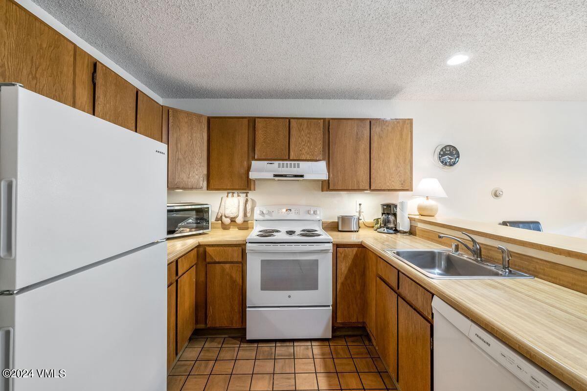 442 South Frontage Road East, Unit A205 Vail, CO 81657 - Photo 10 of 24 a kitchen with a sink a stove and refrigerator
