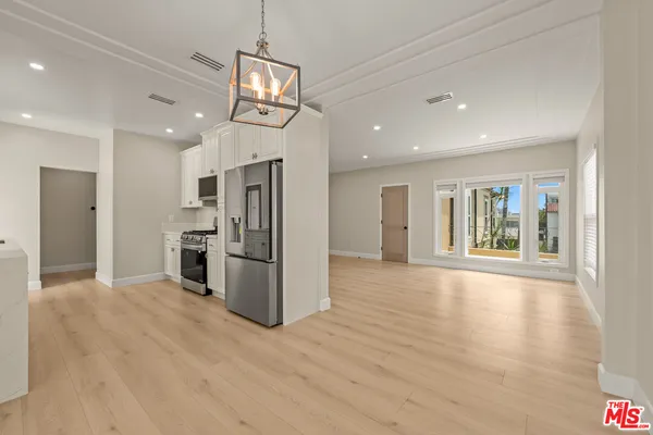 a view of a kitchen with refrigerator and wooden floor