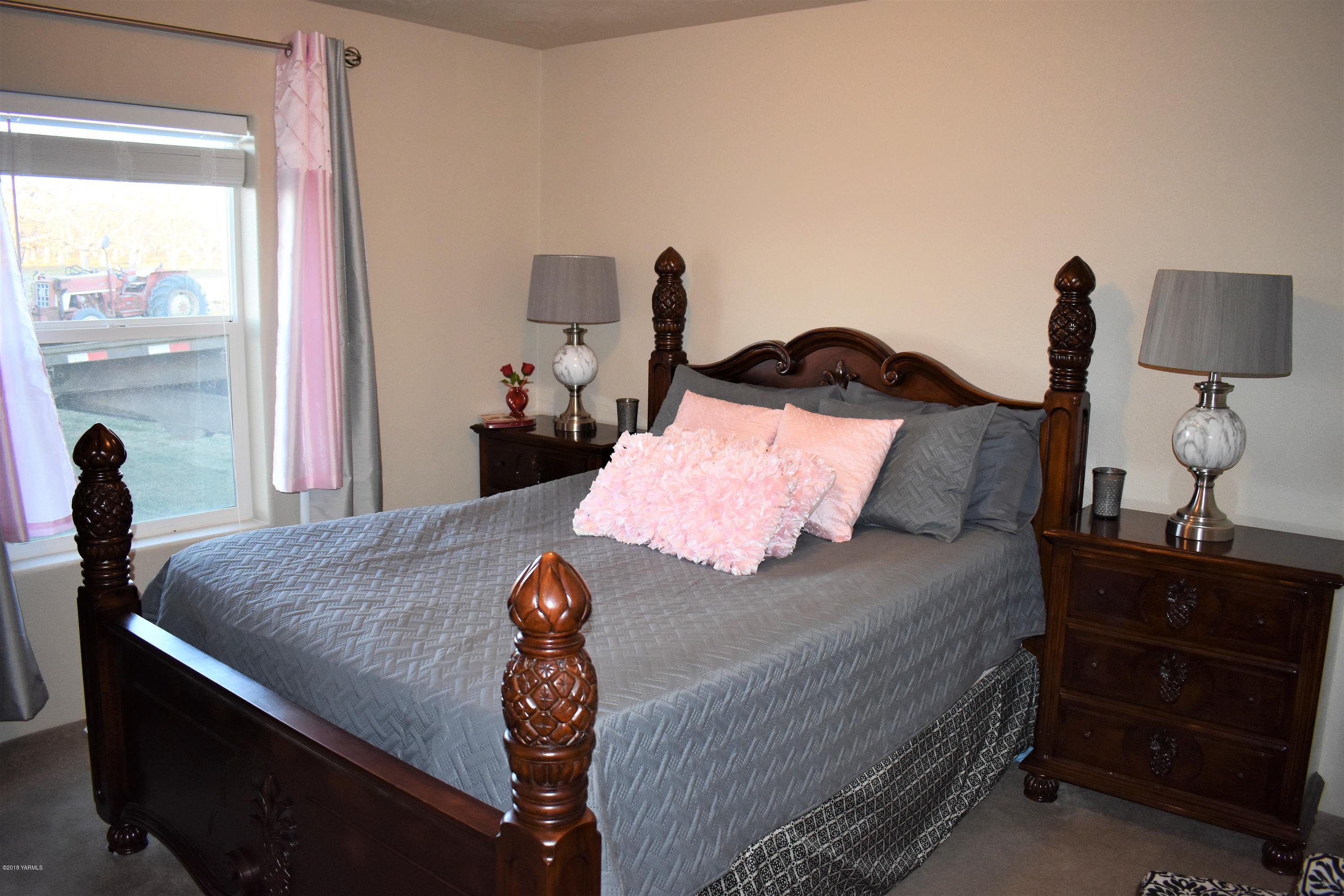 303 Hanks Road Grandview, WA 98930 - Photo 11 of 15 a bedroom with a bed and wooden floor