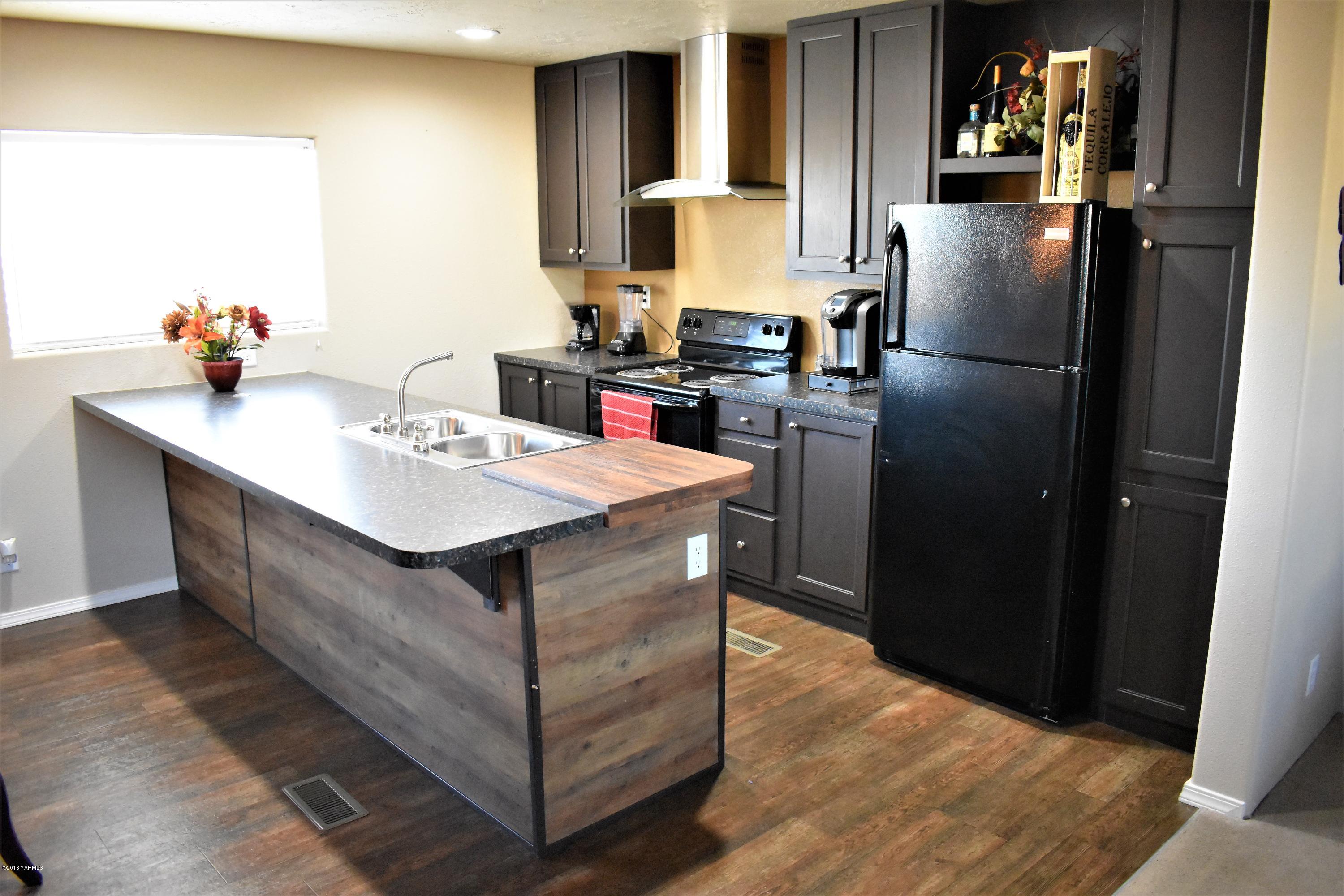 303 Hanks Road Grandview, WA 98930 - Photo 4 of 15 a kitchen with stainless steel appliances granite countertop a refrigerator table and chairs