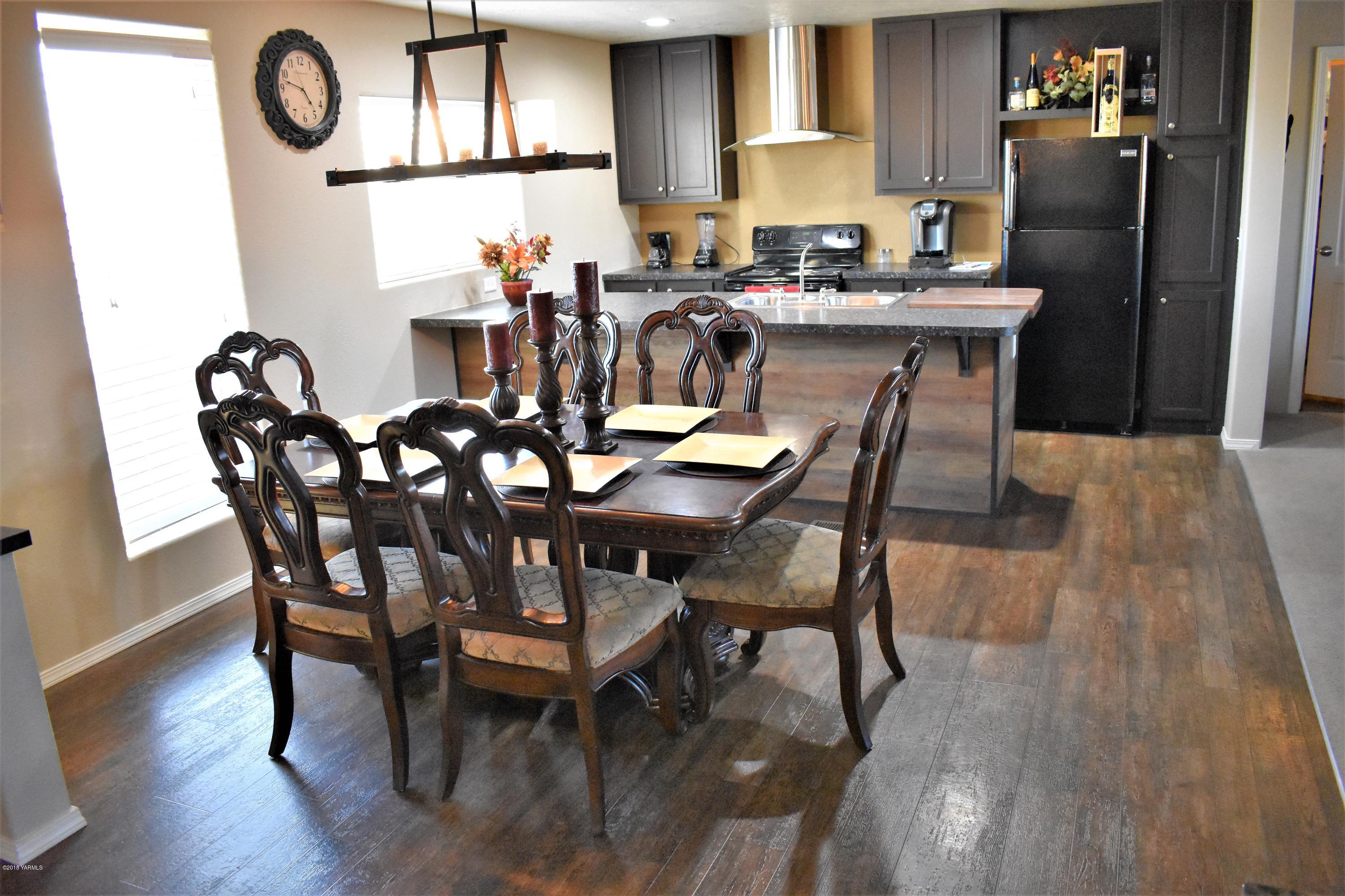 303 Hanks Road Grandview, WA 98930 - Photo 6 of 15 a dining room with furniture a floor to ceiling window and kitchen view