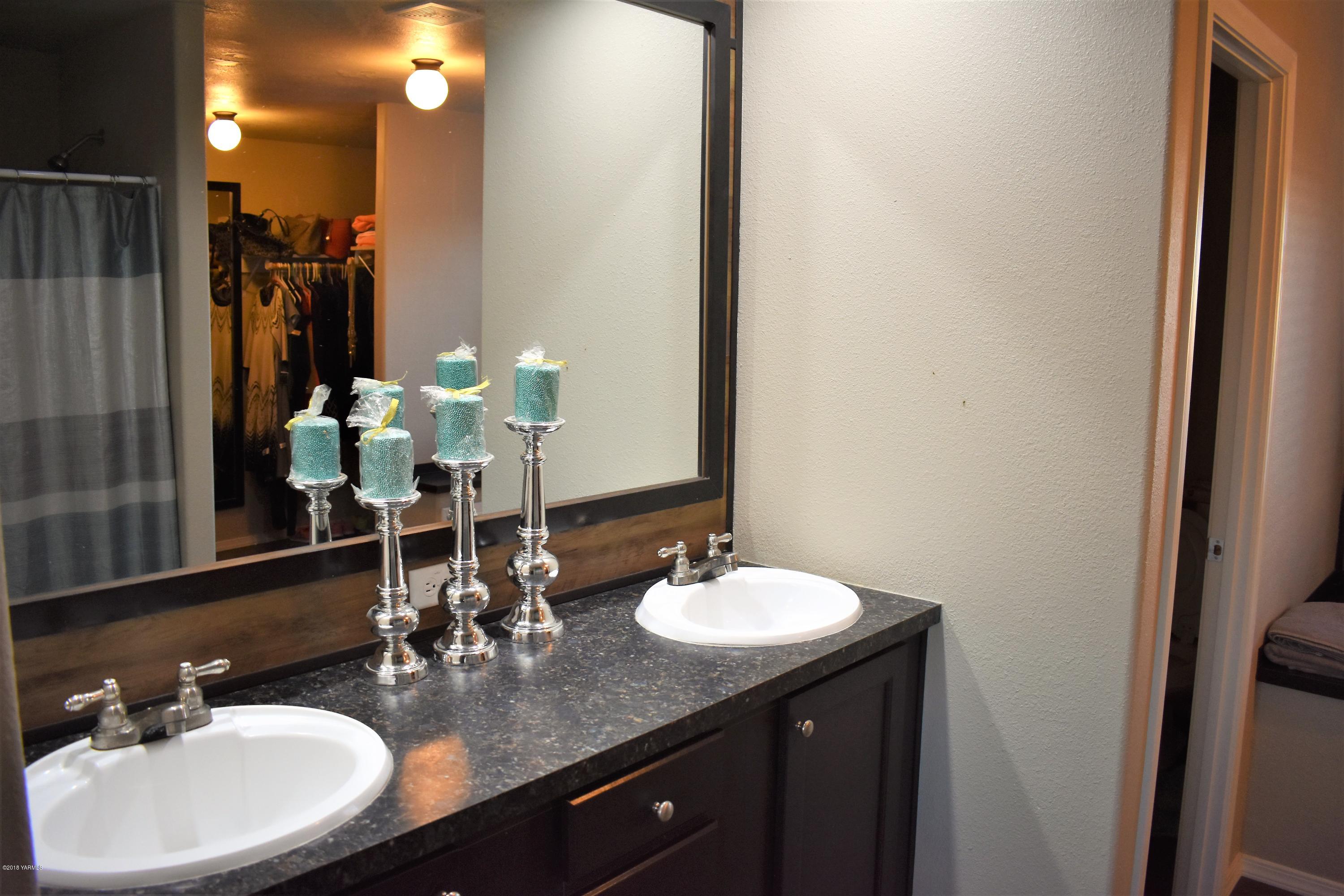 303 Hanks Road Grandview, WA 98930 - Photo 9 of 15 a bathroom with double vanity sinks and a mirror