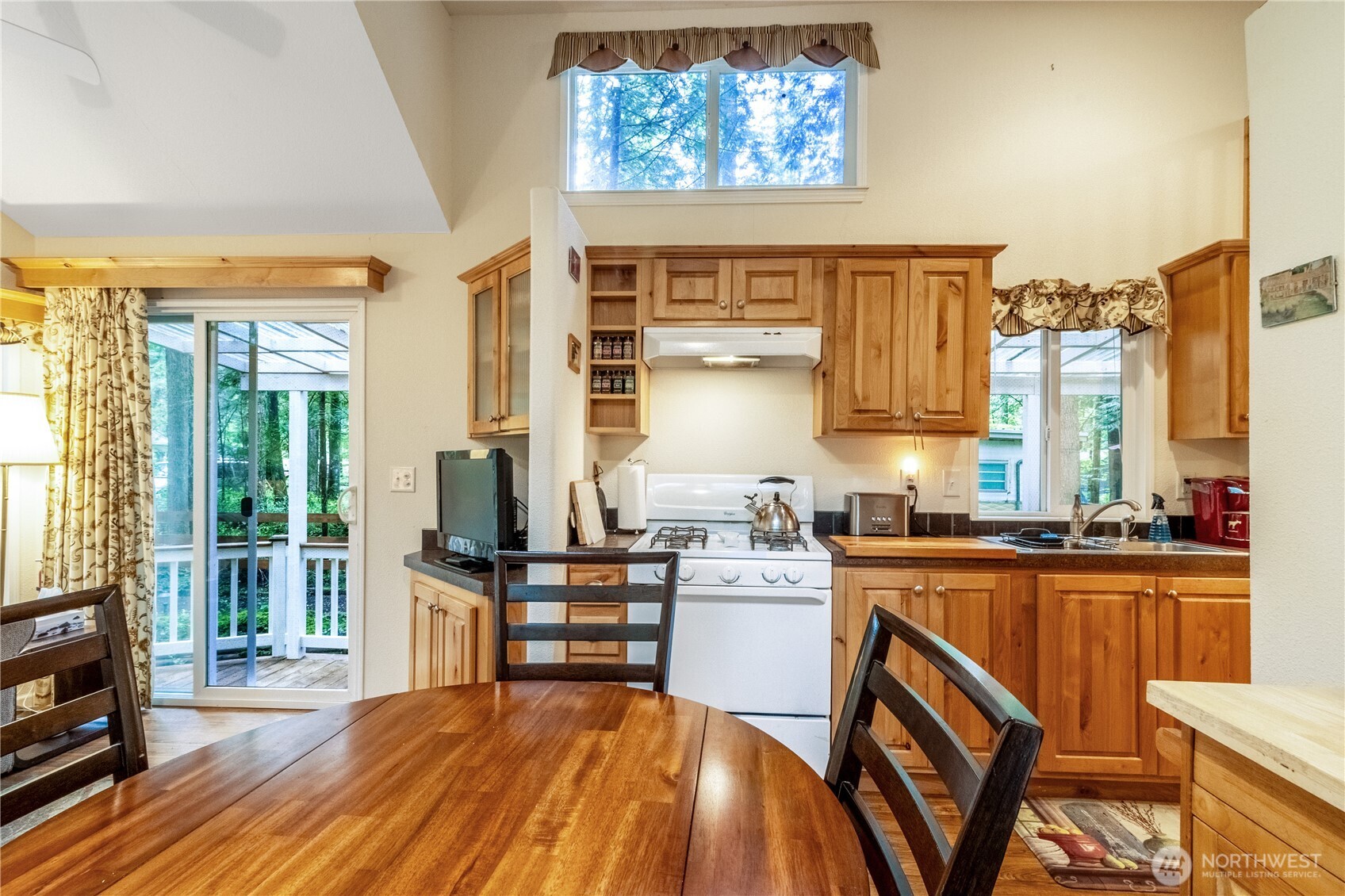 86-3 Sunset Circle Maple Falls, WA 98266 - Photo 11 of 38 a kitchen with stainless steel appliances granite countertop a stove top oven a dining table and chairs with wooden floor