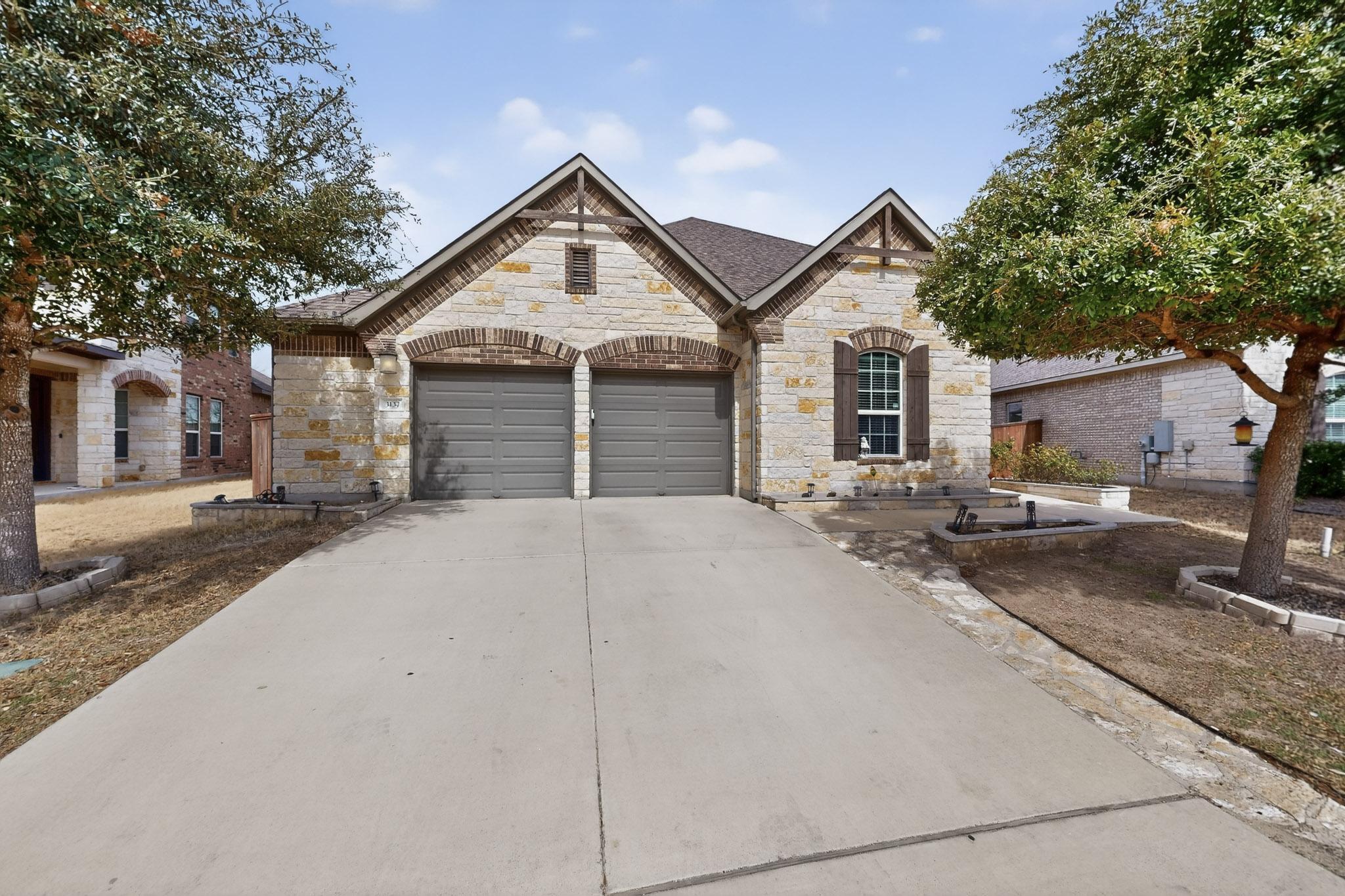 3137 Catalina Ranch Road Leander, TX 78641 - Photo 4 of 21 French country home with stone siding, concrete driveway, and a garage
