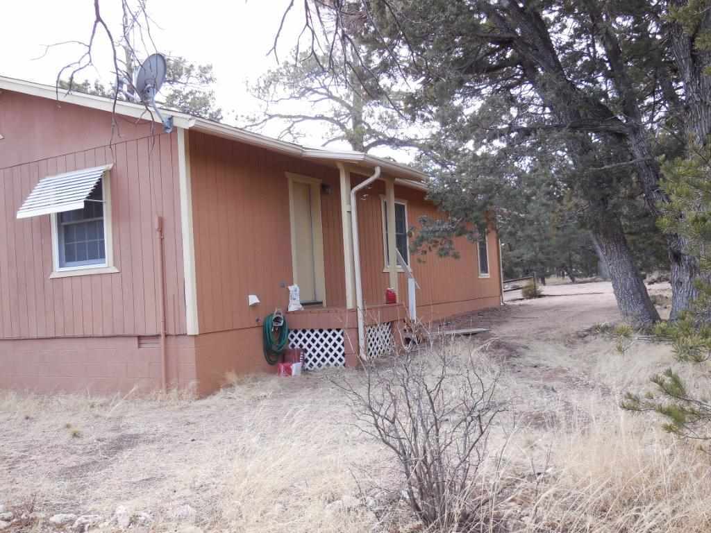 3060 A Chevelon Road Overgaard, AZ 85933 - Photo 12 of 14 a view of a house with a large tree and wooden fence
