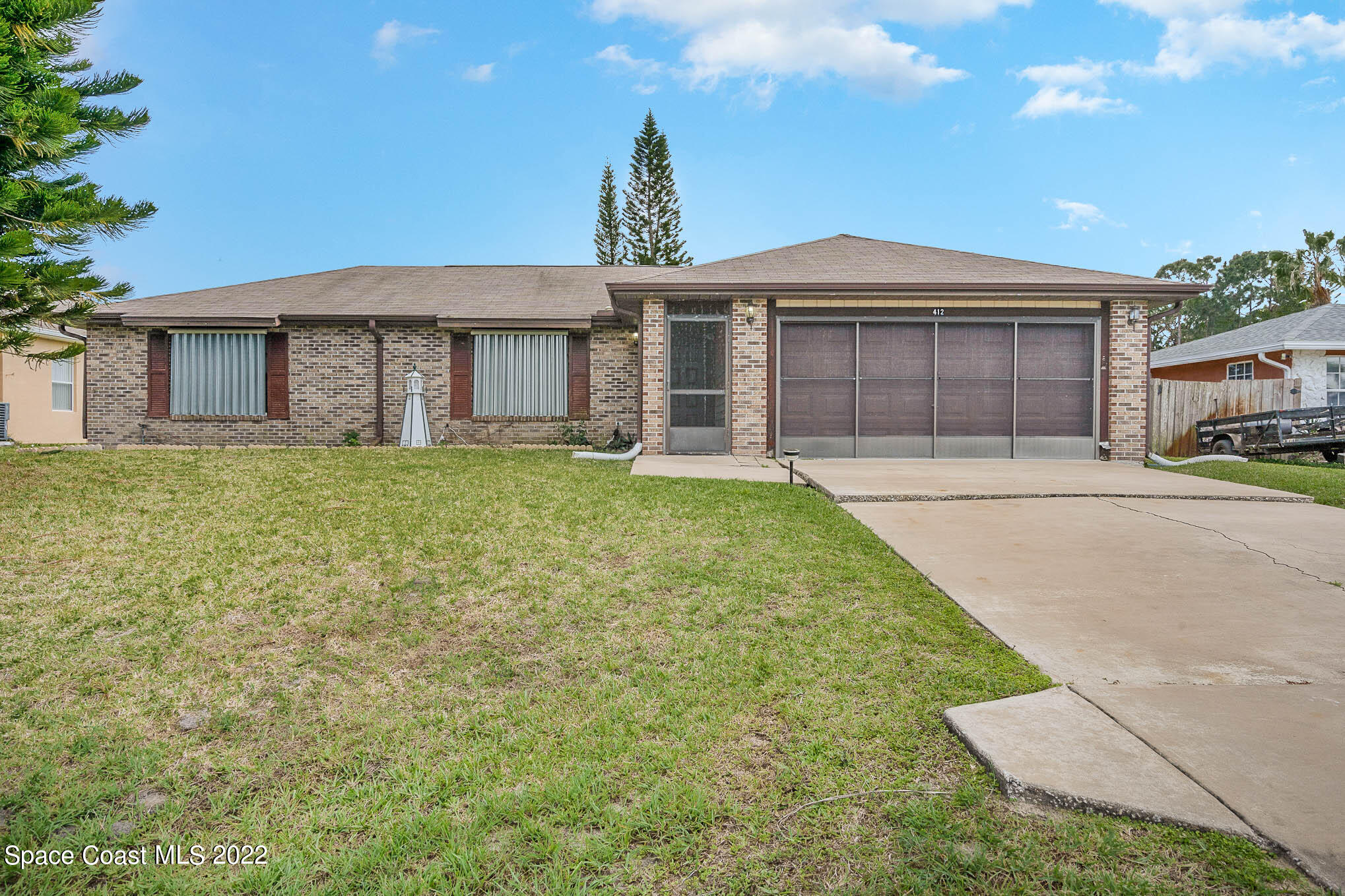 412 Godfrey Road Southeast Palm Bay, FL 32909 - Photo 1 of 22 a front view of a house with a yard and garage