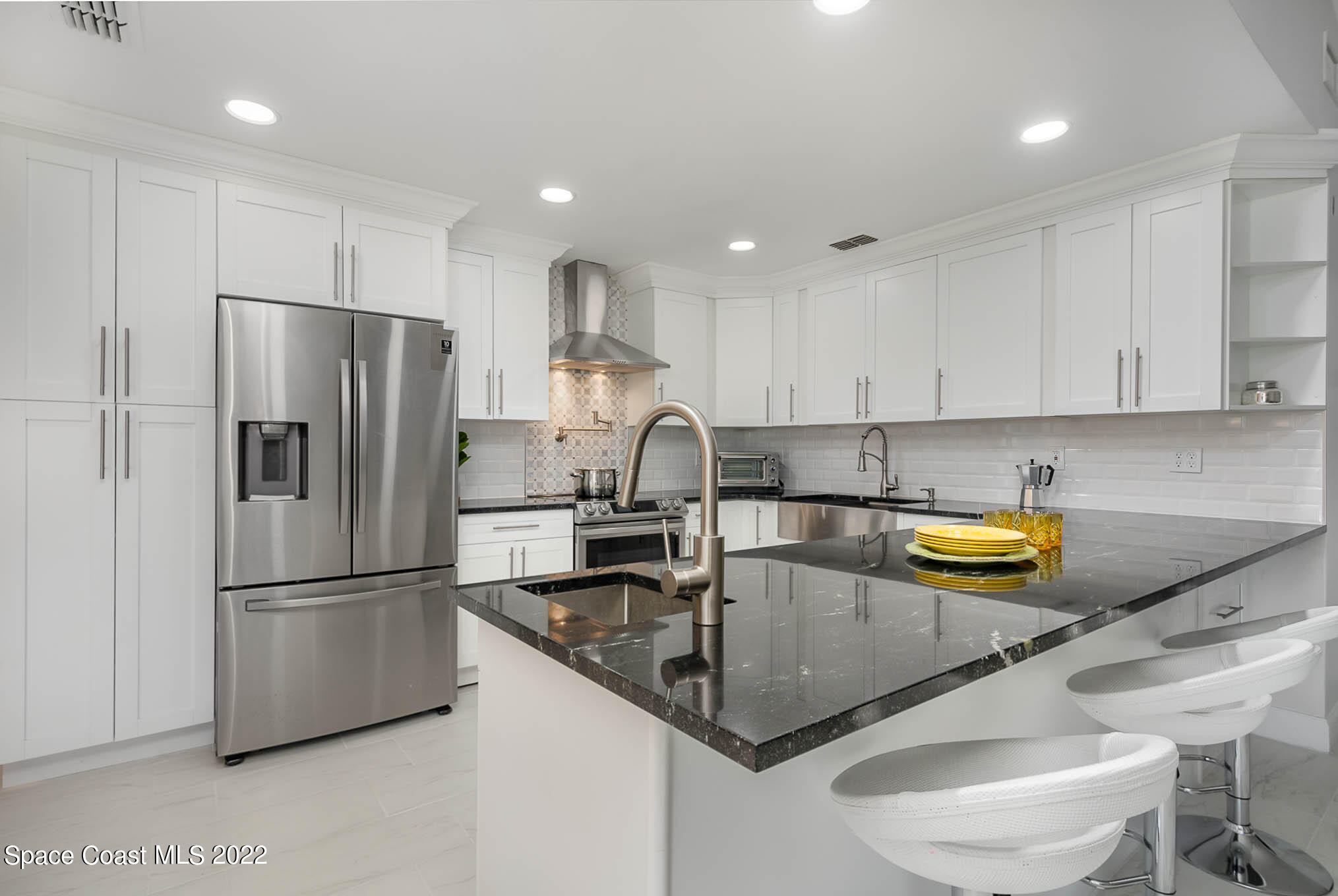 412 Godfrey Road Southeast Palm Bay, FL 32909 - Photo 5 of 22 a kitchen with stainless steel appliances granite countertop a sink a refrigerator and a stove