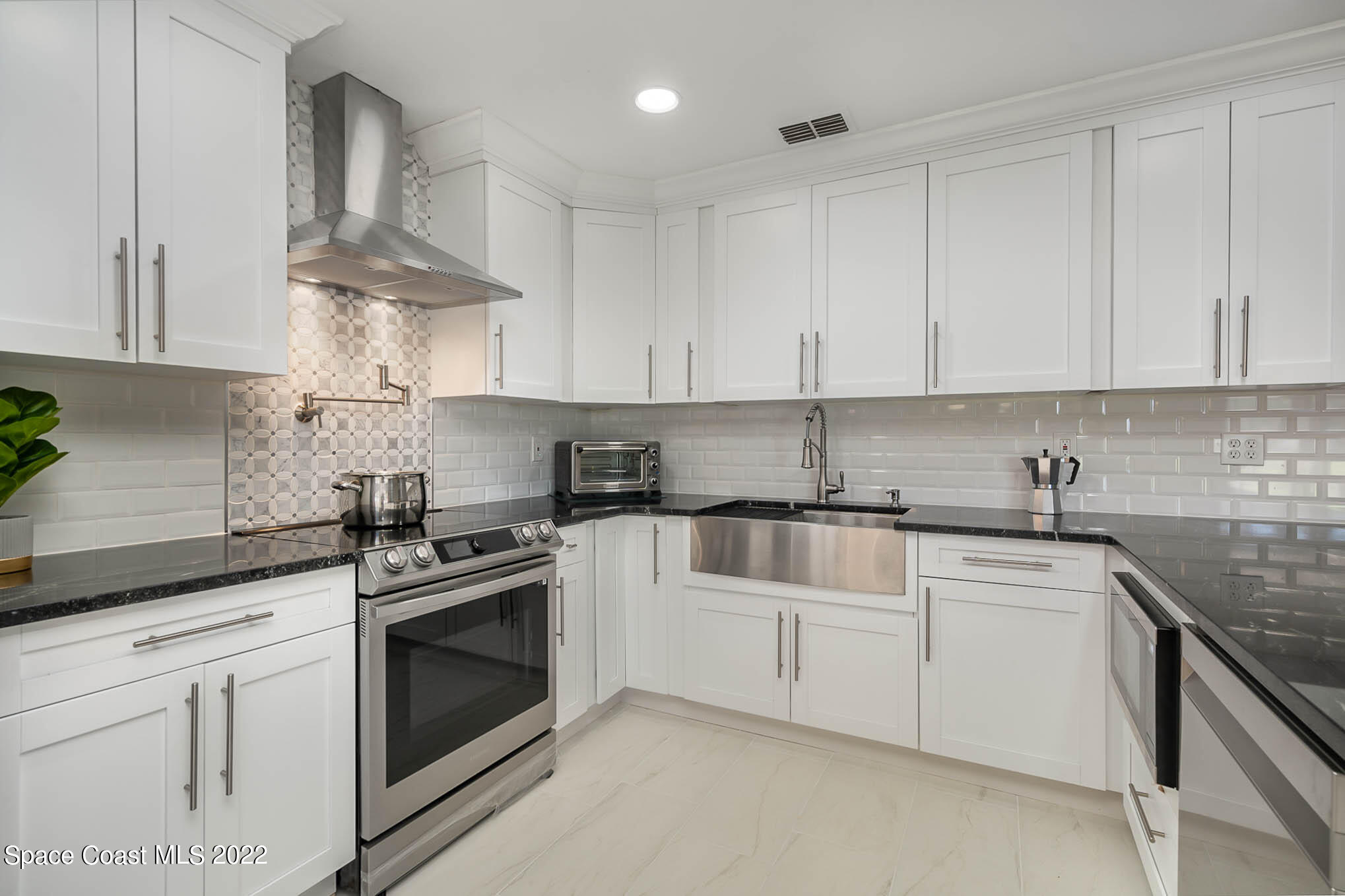 412 Godfrey Road Southeast Palm Bay, FL 32909 - Photo 6 of 22 a kitchen with white cabinets stainless steel appliances and sink