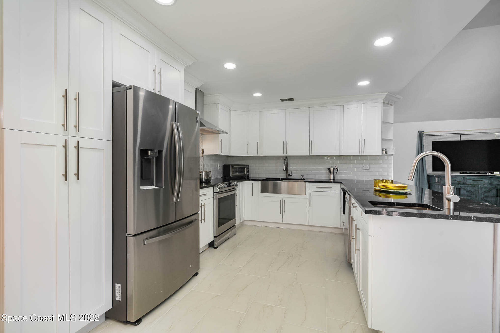 412 Godfrey Road Southeast Palm Bay, FL 32909 - Photo 7 of 22 a kitchen with stainless steel appliances a refrigerator sink and white cabinets