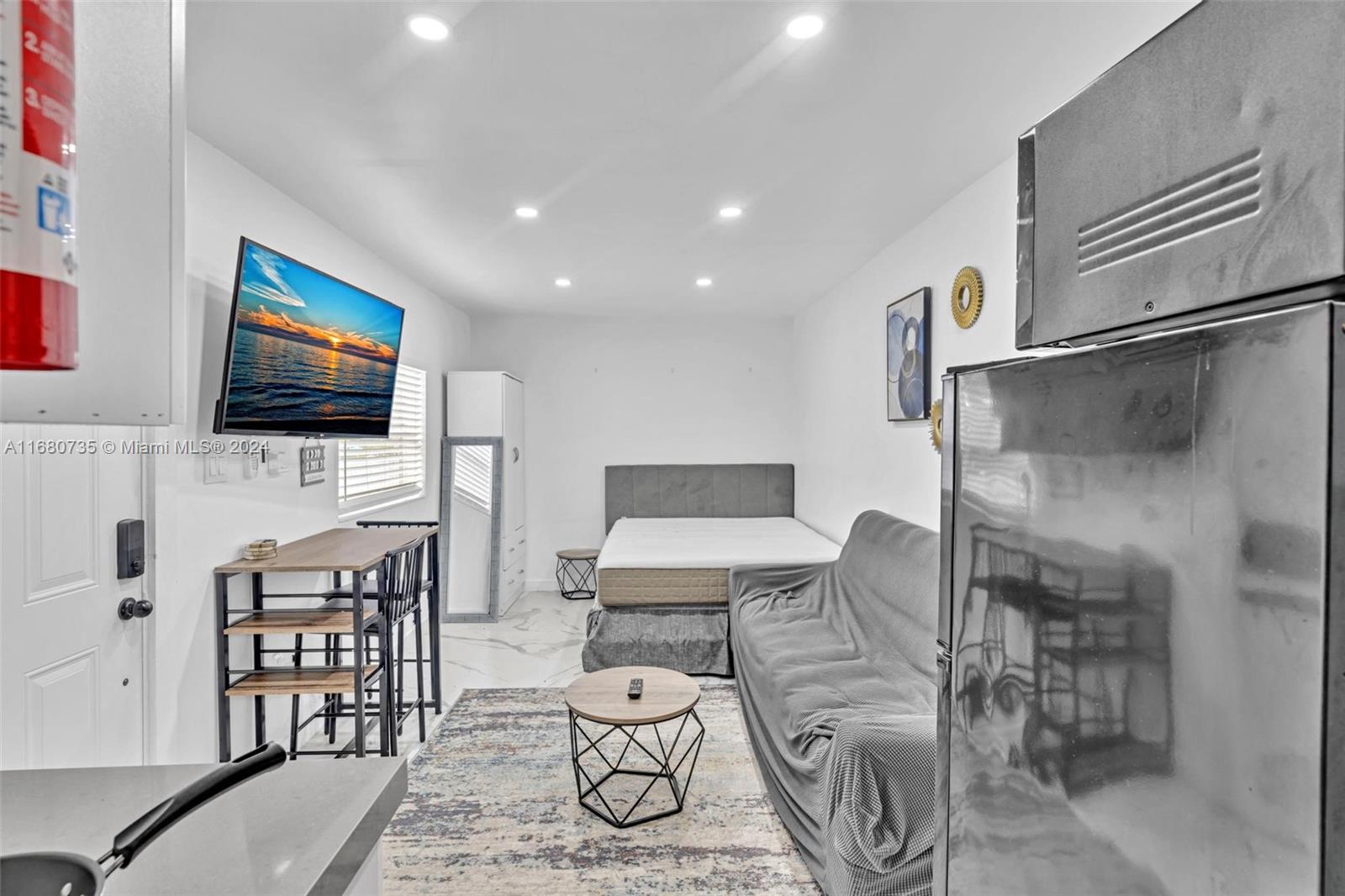 4328 Southwest 49th Court, Unit 2 Dania Beach, FL 33314 - Photo 4 of 18 a living room with furniture and a flat screen tv