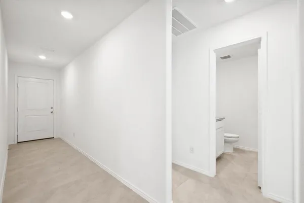 a view of room with a hallway and toilet