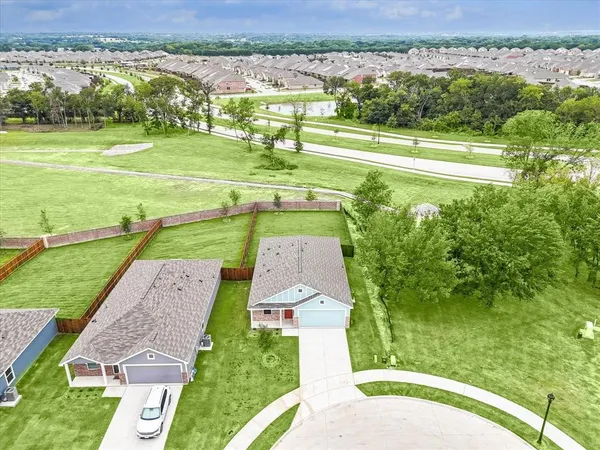 an aerial view of a houses with a yard and lake view