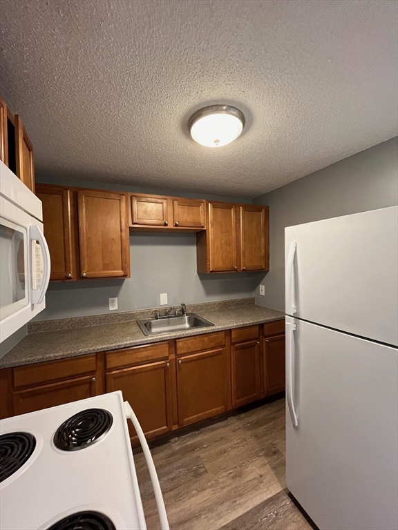 1475 Braley Road, Unit 17 New Bedford, MA 02745 - Photo 3 of 9 a kitchen with a sink a refrigerator and cabinets